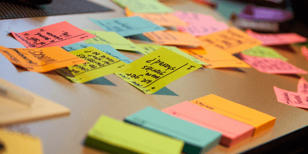 Images shows a tables with all different coloured post it notes to show event marketing planning