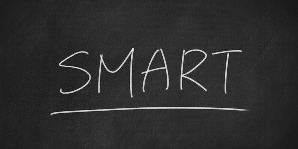 images shows the word 'smart' written on a blackboard in white chalk