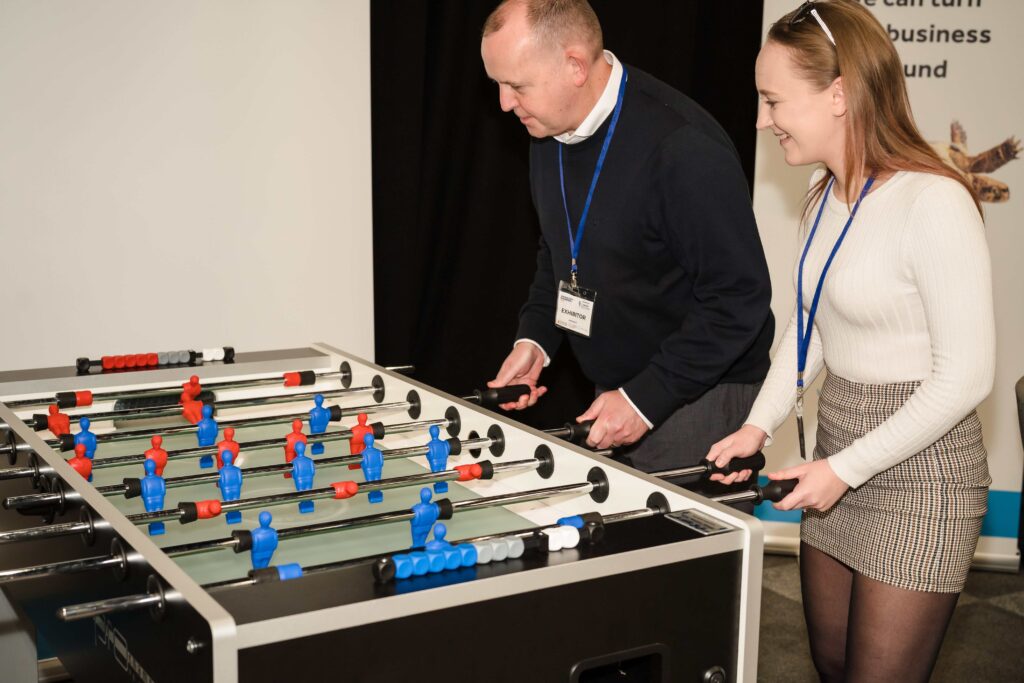 Chris Brown and colleague playing table football on their Blackpool Expo stand